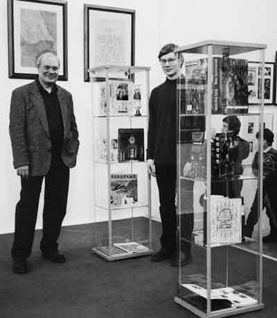 А.Рюмин с сыном Алексеем у витрин с книгами, оформленными А.Рюминым, на 20-й выставке московских художников книги. 2003. Фото Е.Пашутиной